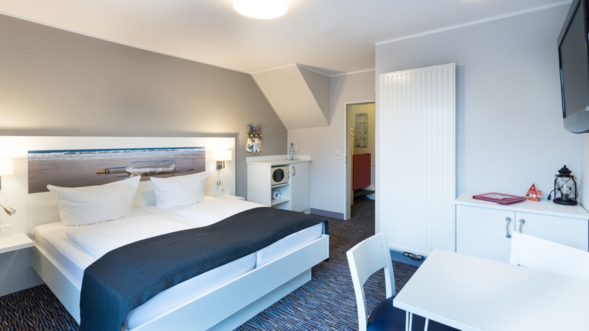 Doppelbett und Sitzecke in der unteren Etage der Familien Suite Typ B